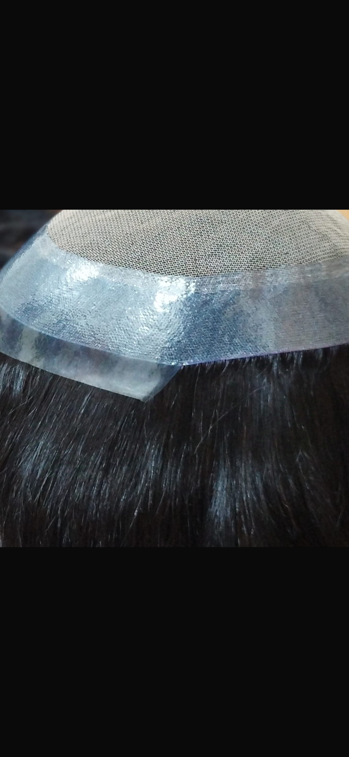 Close-up of hair system base construction showing mono and poly materials